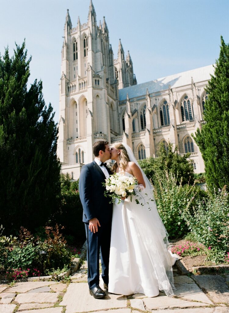 Bride and groom kiss outside National Cathedral in washington dc. hand calligraphy wedding stationery. Laura Hooper Design House. 