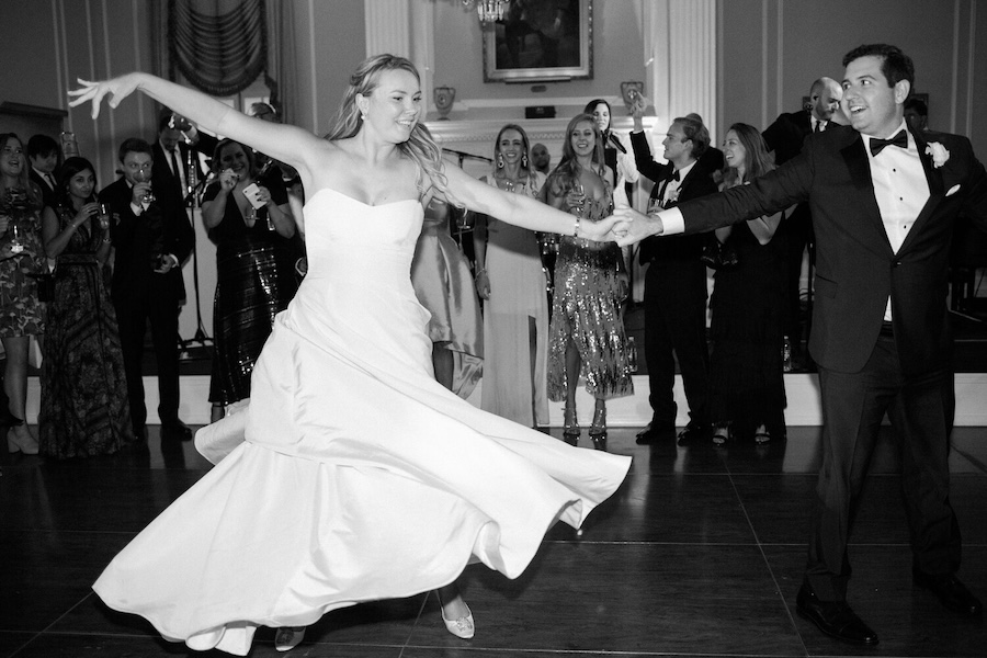 Bride in strapless dress twirls with groom in ballroom. Laura Hooper Design House. 