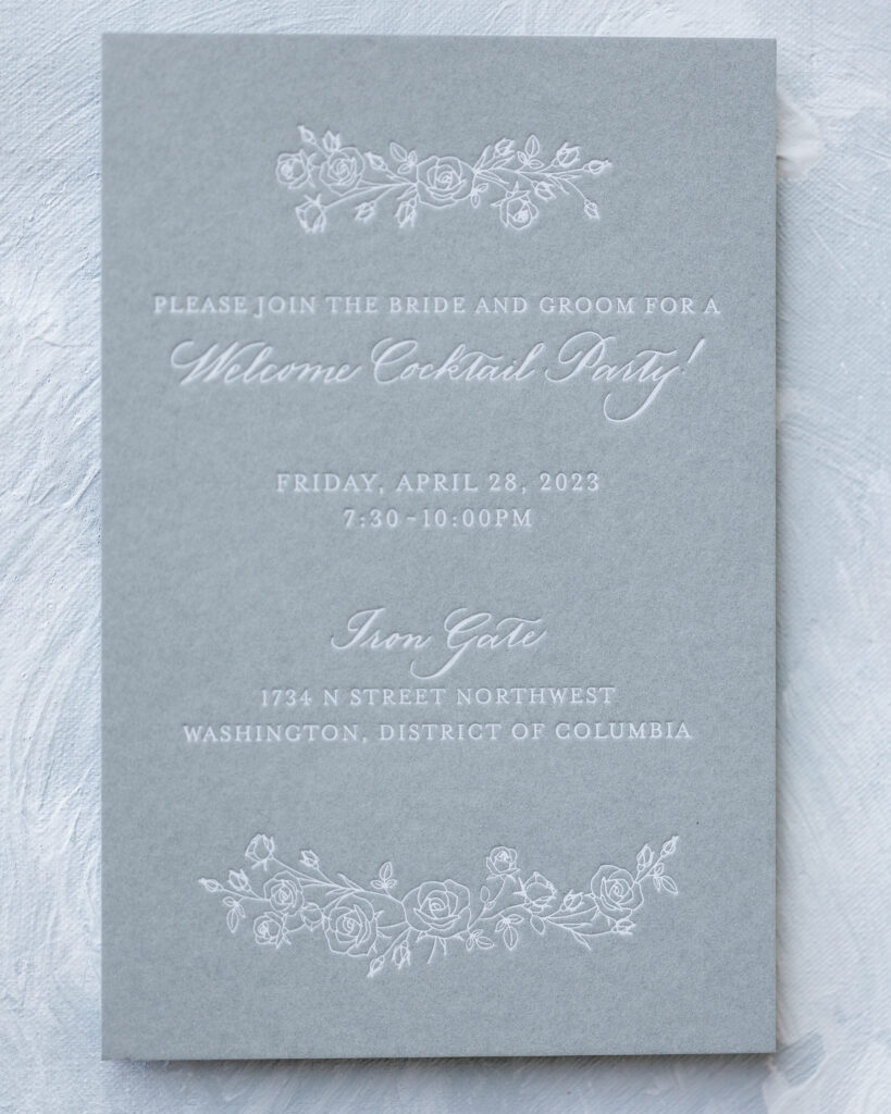 Grey Blind debossed wedding invitation in an enlarged rose pattern.