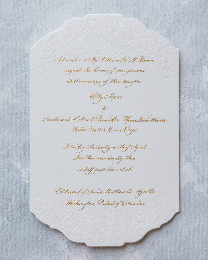 Blind deboss rose pattern wedding invitation with with lettering stamped over in gold foil in Laura Hooper’s signature Rosen script style.