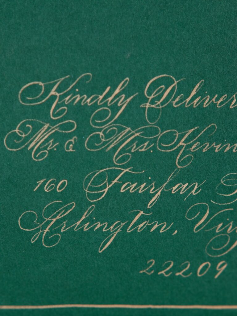 Custom wedding invitation with gold calligraphy on emerald green envelope by Laura Hooper Design House