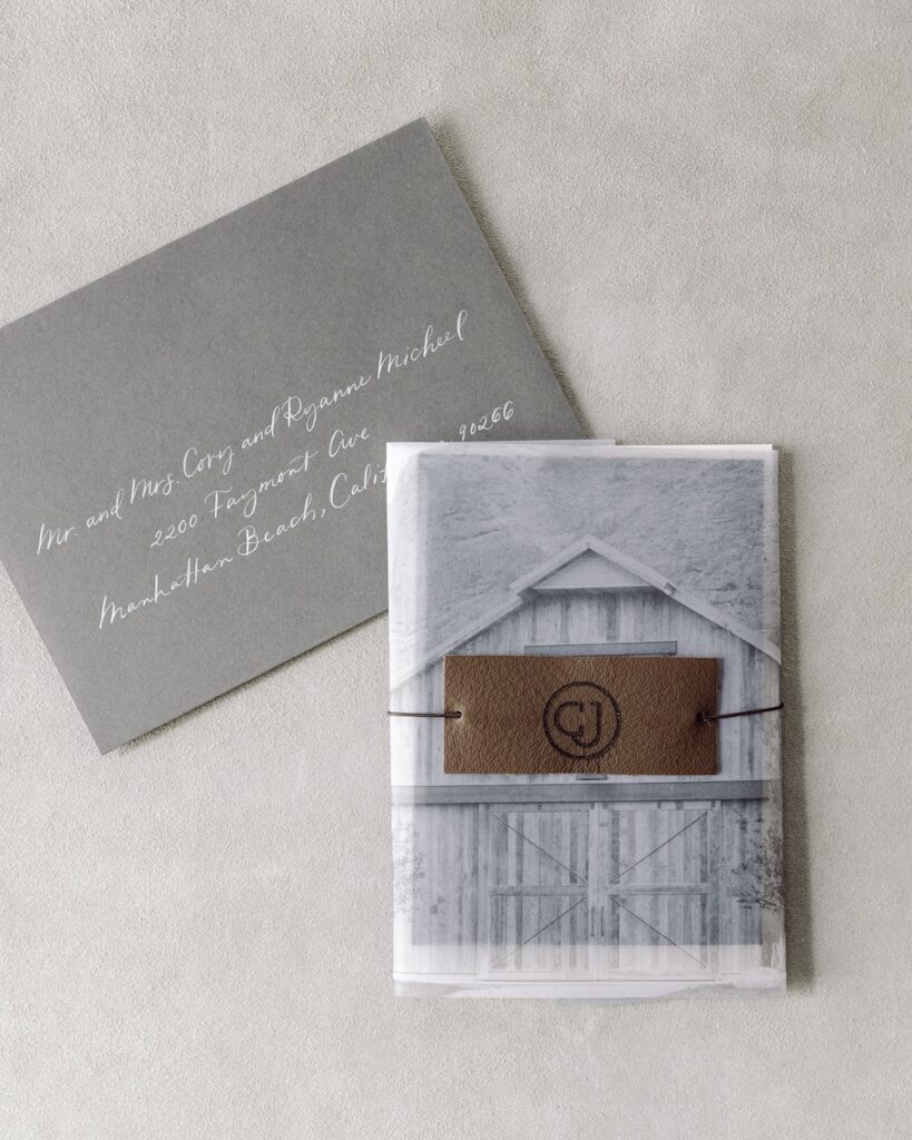 Modern charcoal grey wedding invitation envelope with white calligraphy and photo of barn, Laura Hooper Design House. 