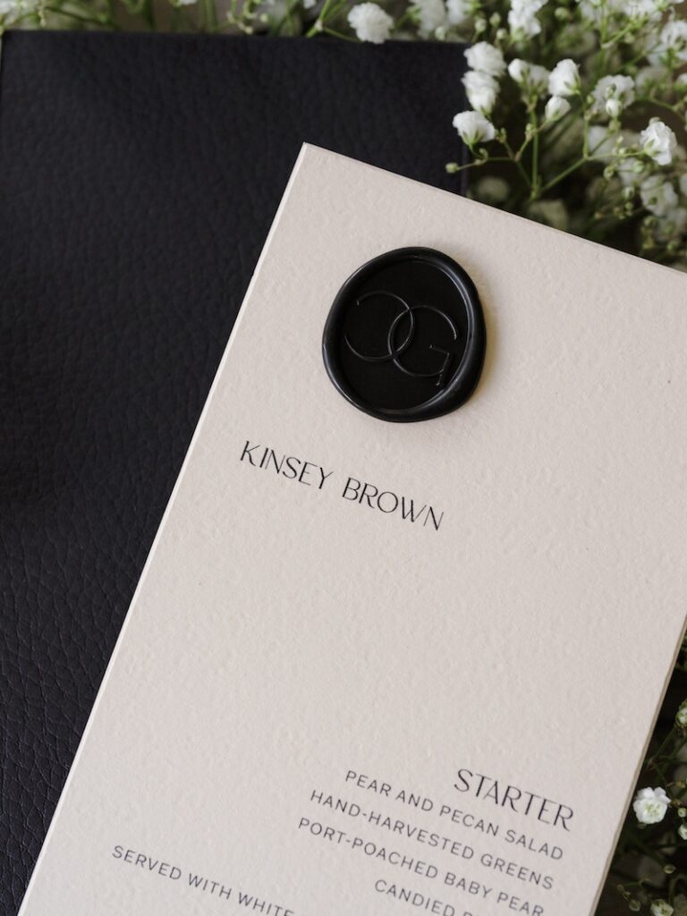 Custom wax seal on wedding menu that doubles as place card. Custom wedding stationery & paper details. Laura Hooper Design House. 