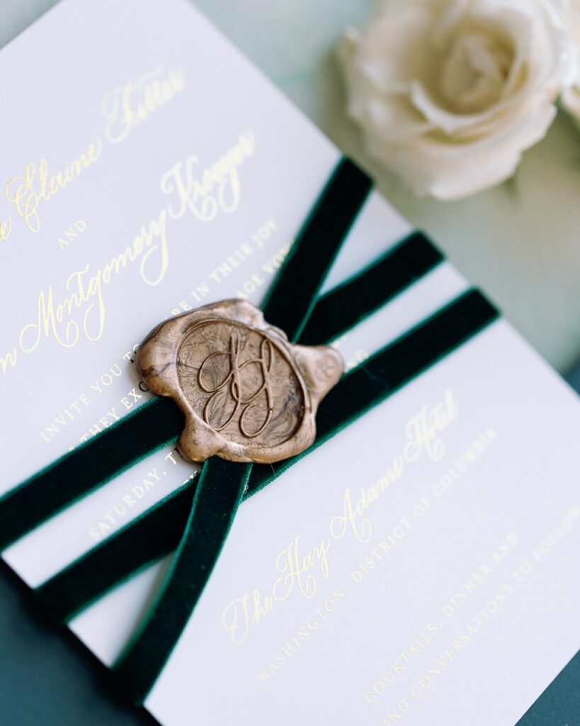 Custom monogram wax seal on white cardstock wedding invitation with goil foil wrapped in velvet green ribbon. Laura Hooper Design House. 
