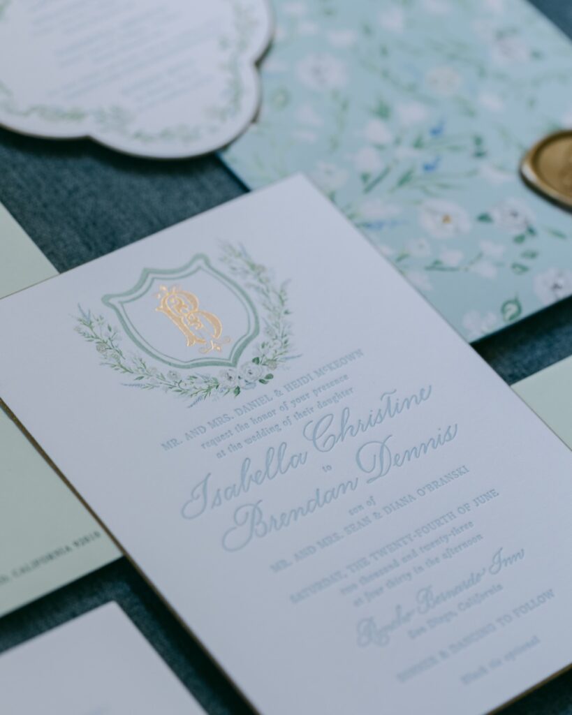 Custom gold foil monogram crest with watercolor floral details. Luxe wedding invitation. Laura Hooper Design House. 