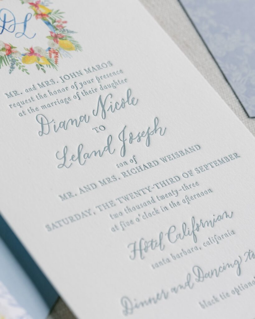 Custom wedding invitation, letterpress and digital printed, watercolor monogram crest, dusty blue text. Laura Hooper Design House.