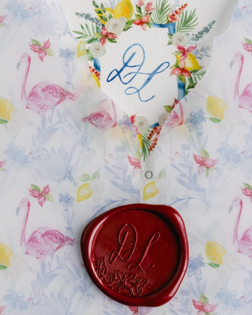 Custom monogram wax seal, flamingo patterned die cut vellum wedding invitation wrap. Laura Hooper Design House.