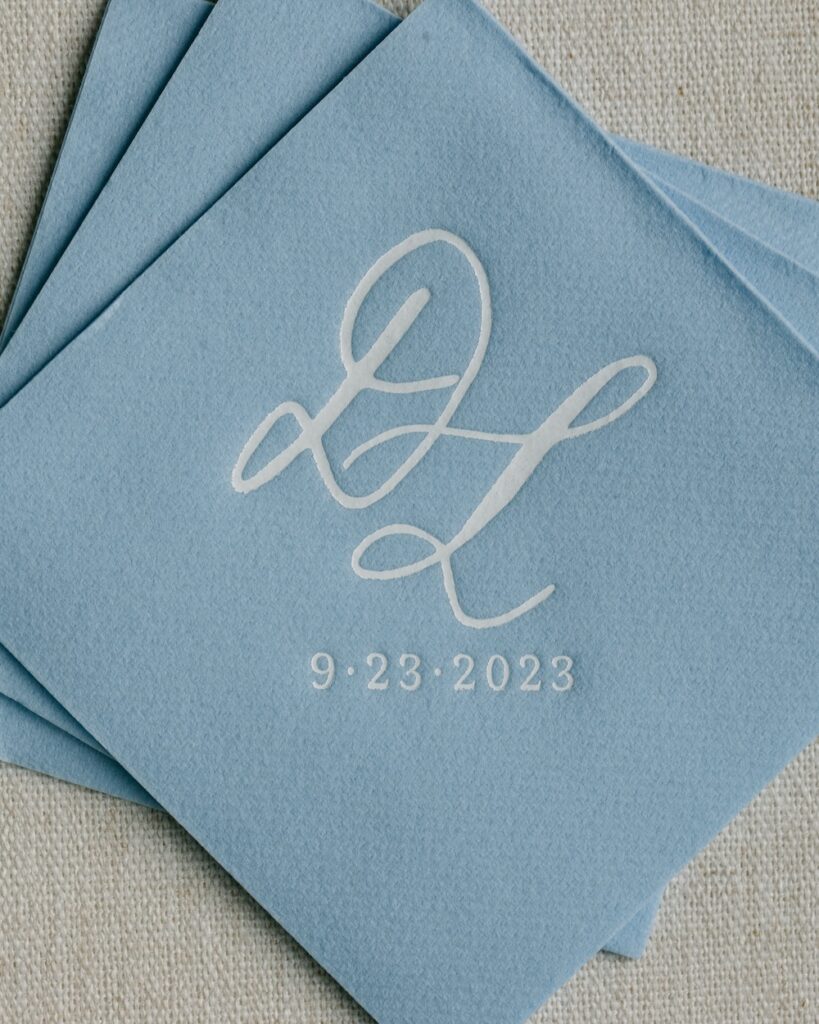 Custom dusty blue wedding cocktail napkins with calligraphy monogram. Laura Hooper Design House.